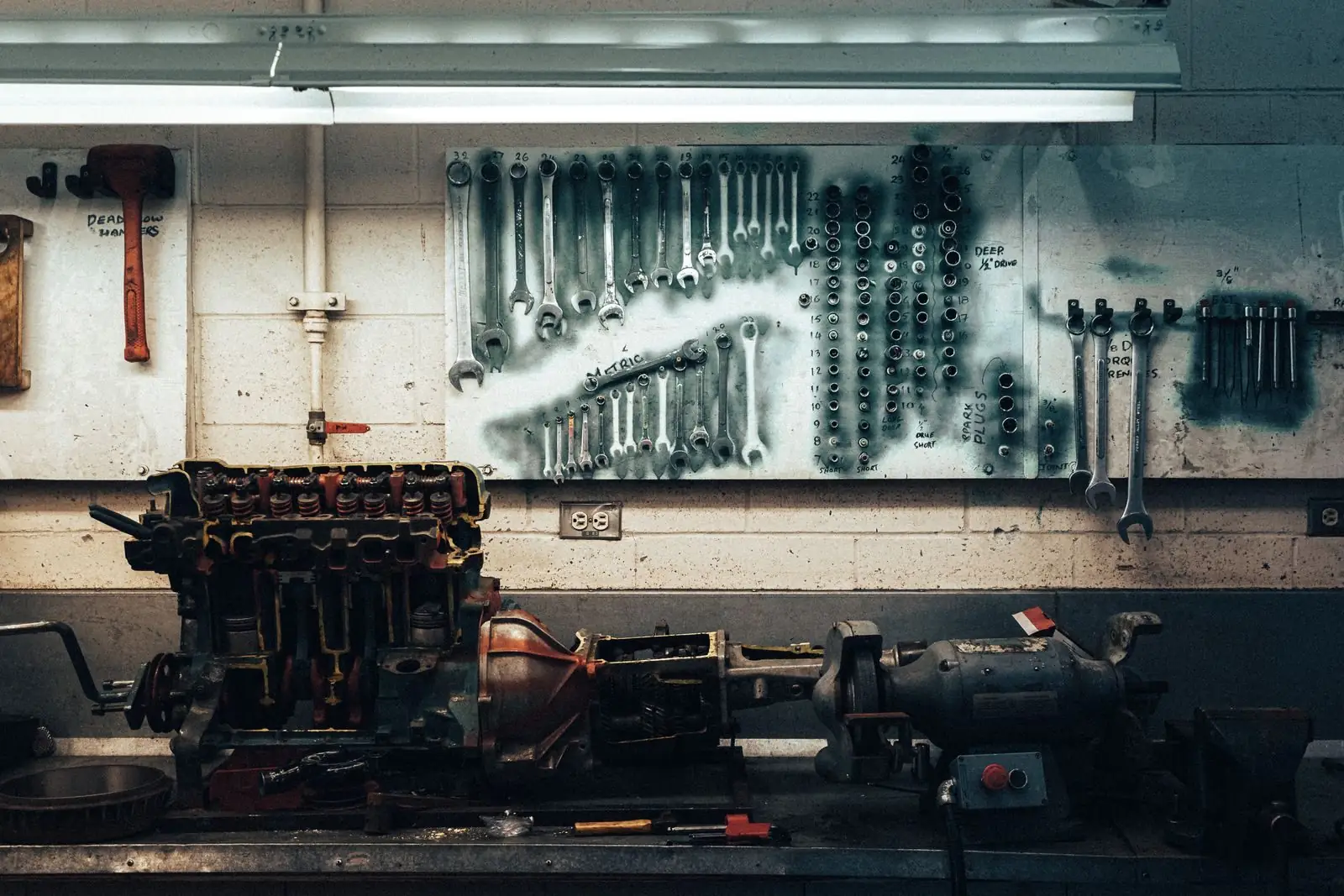 Pared de un taller con llaves colgadas sobre un motor
